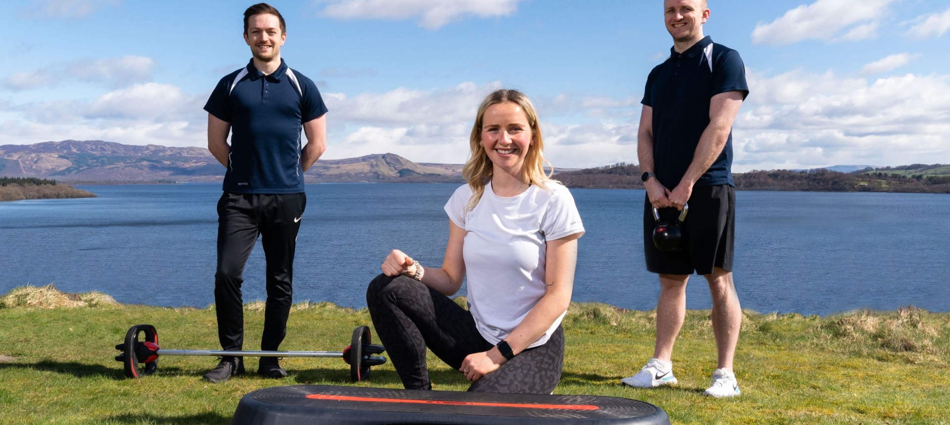Three members of the Cameron House Leisure club post for a photo with exercise equipment