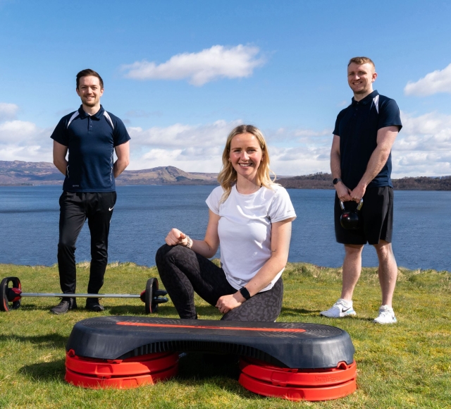 Three members of the Cameron House Leisure club post for a photo with exercise equipment