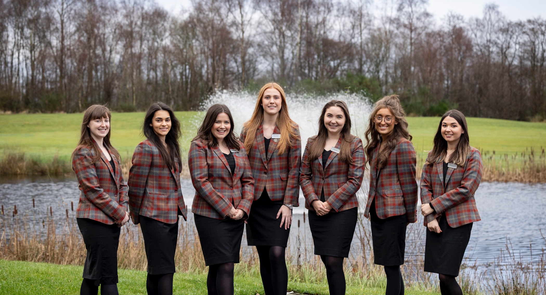 7 members of the grad membership program standing in front of a water fountain