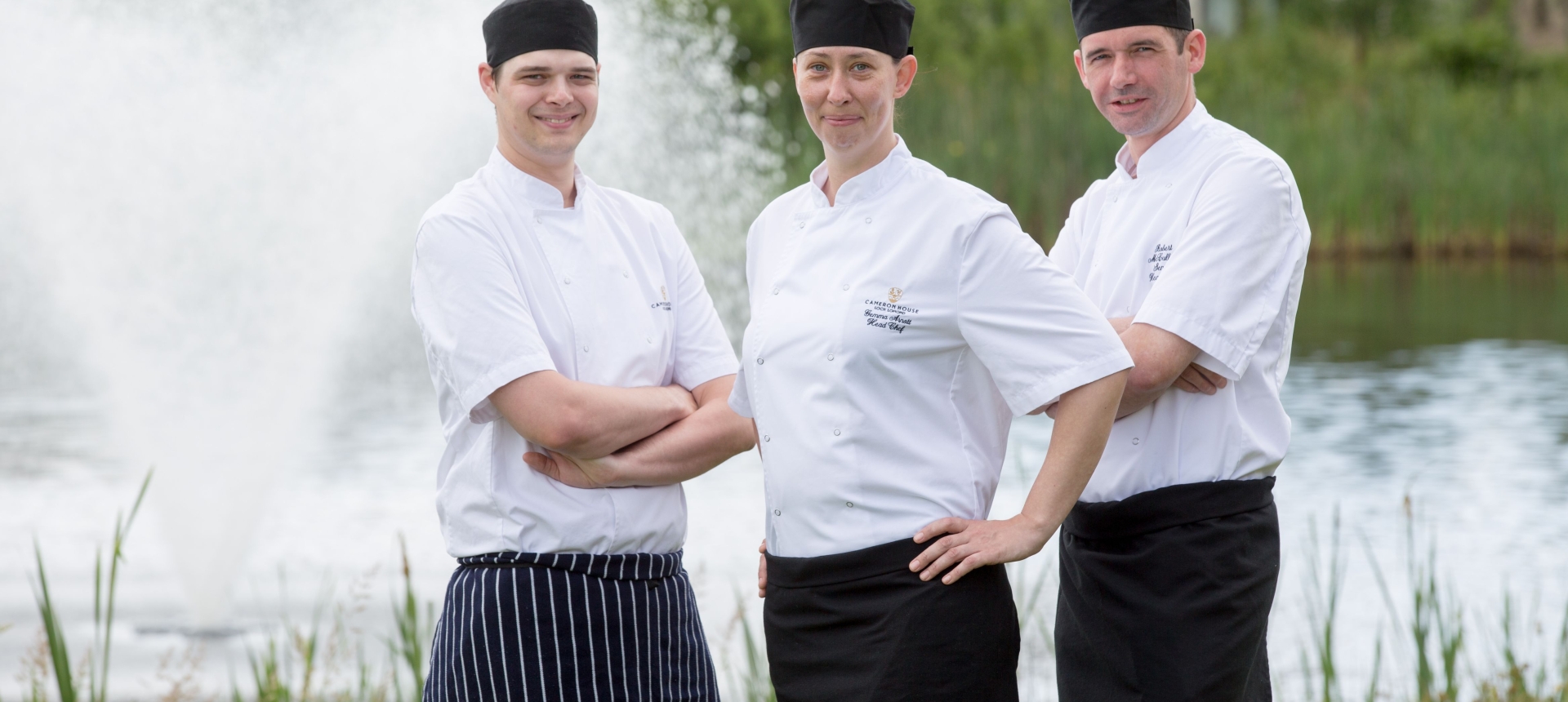 Three Cameron House chefs standing together in front of a water fountain