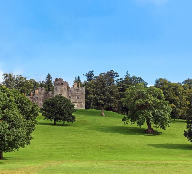 A Scottish castle with a lush green lawn in Balloch Country
