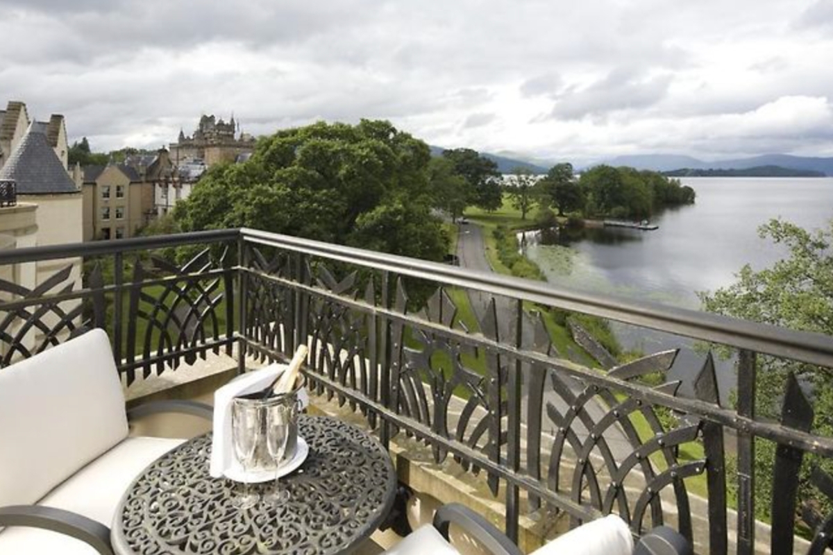 A patio table and chairs on a terrace overlooking Loch Lomond