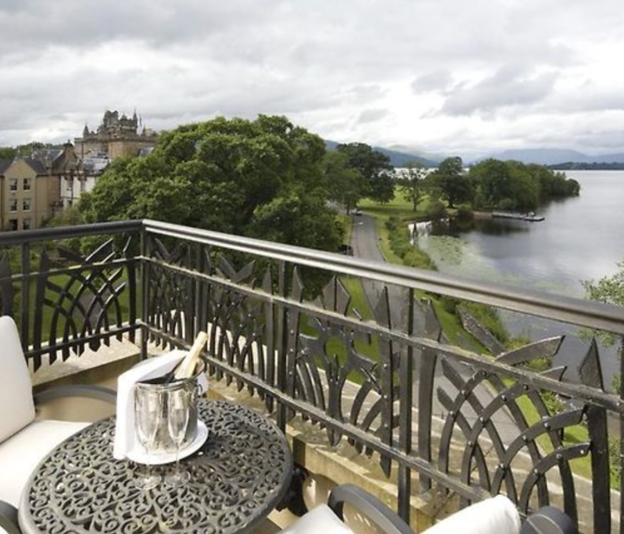 A patio table and chairs on a terrace overlooking Loch Lomond