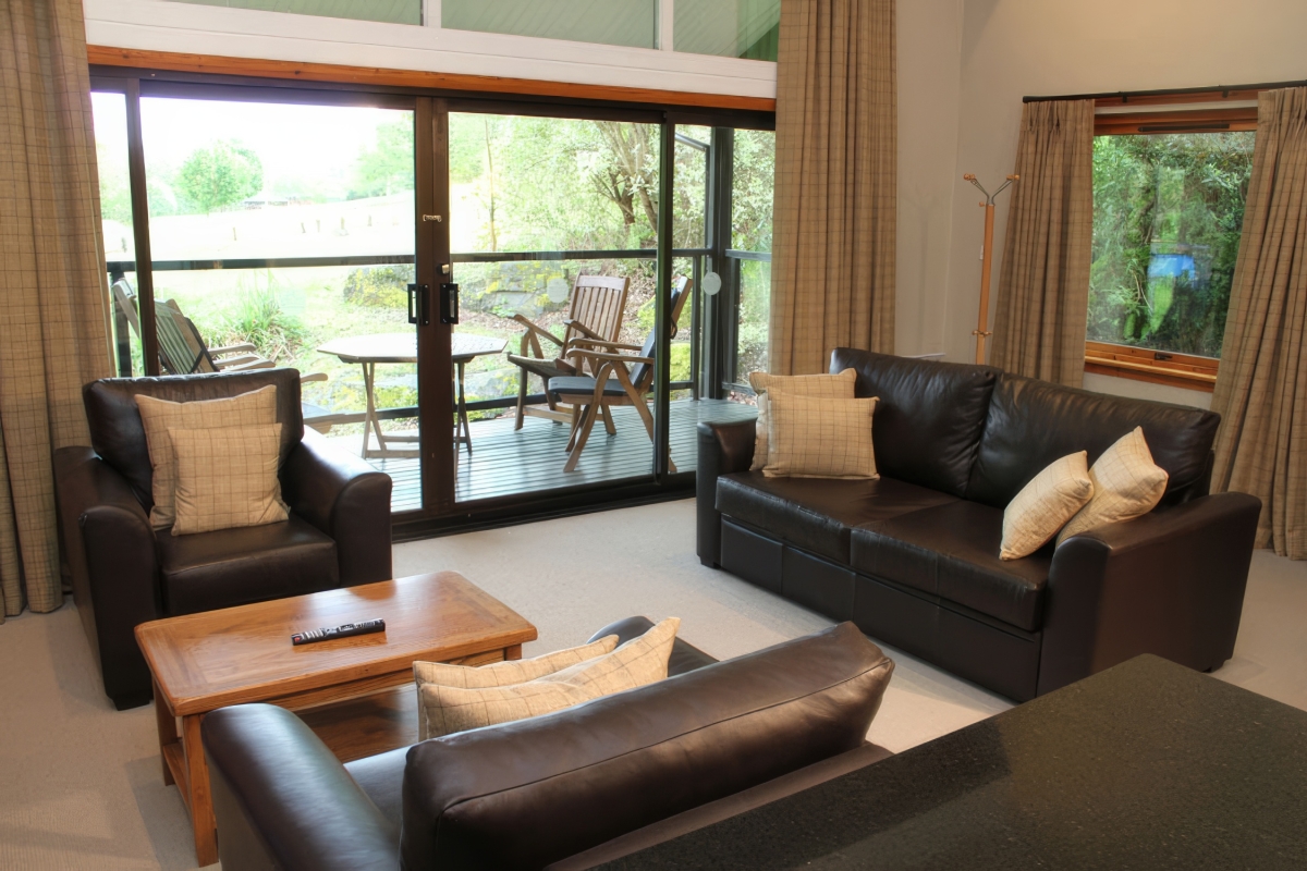a comfortable seating area with comfortable leather chairs and sofas