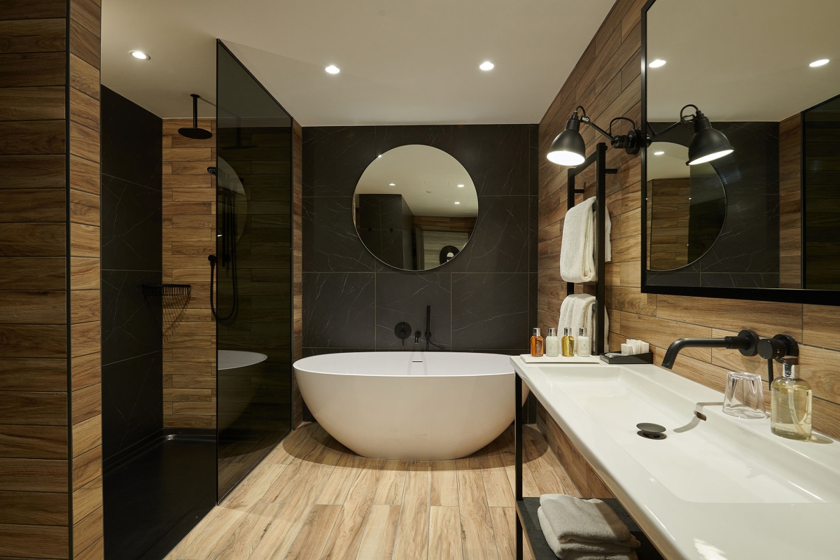 a bathroom with a full sized tub and a sink along the side of the wall and a shower area to the left