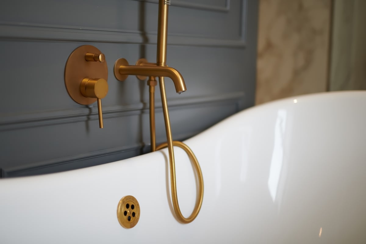 close up details of the gold coloured bathtub faucet..