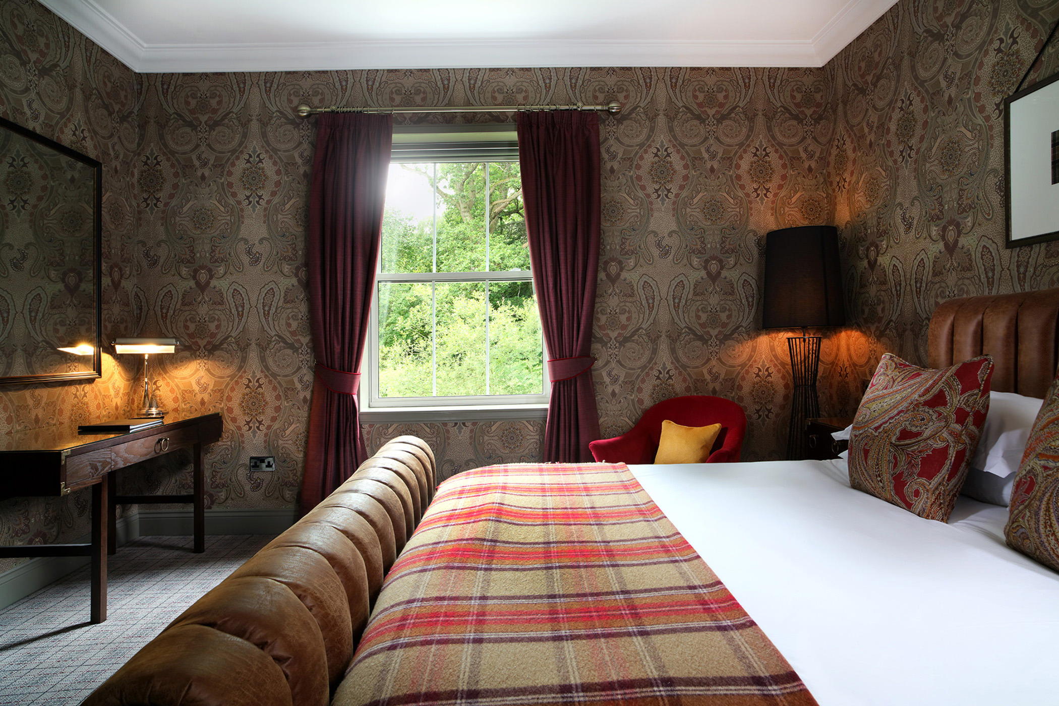 a made bed with a window letting in natural lighting