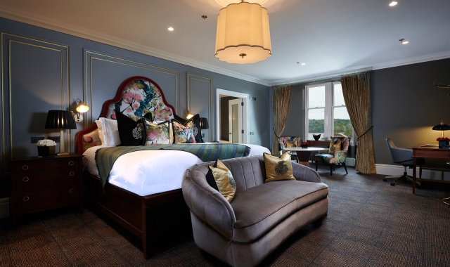 a large bed room with floral patterns on the head board of the bed