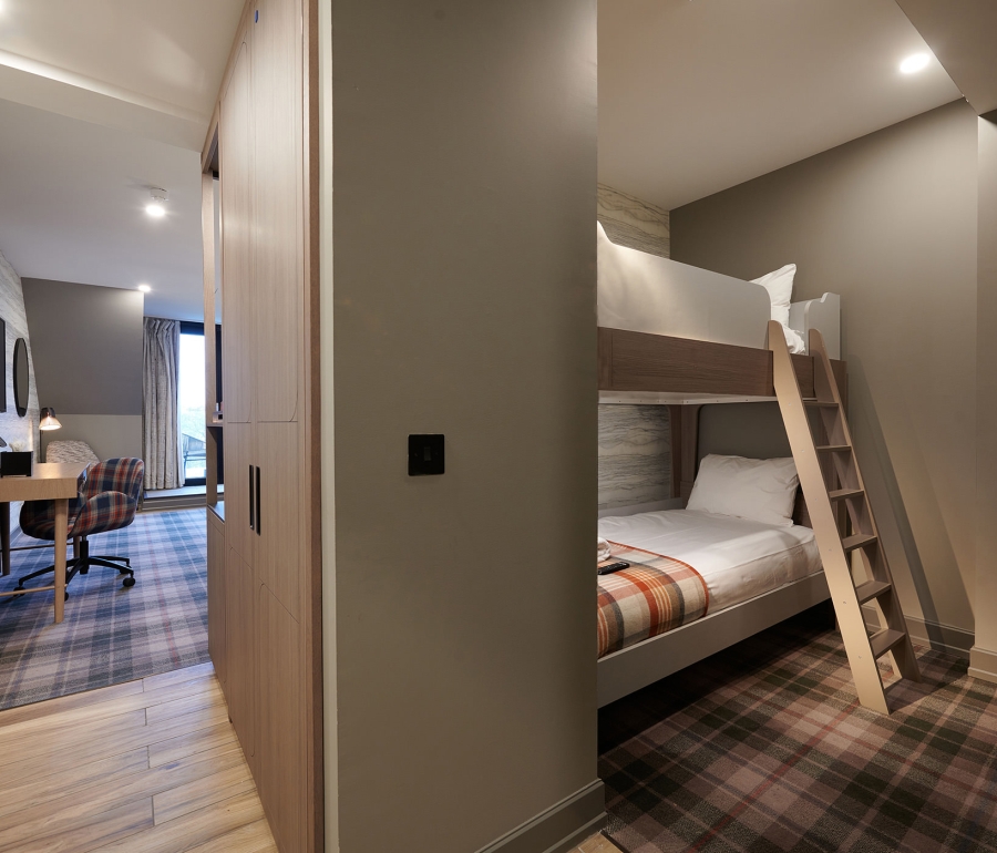 a bunk bed set up around the corner from a bed room