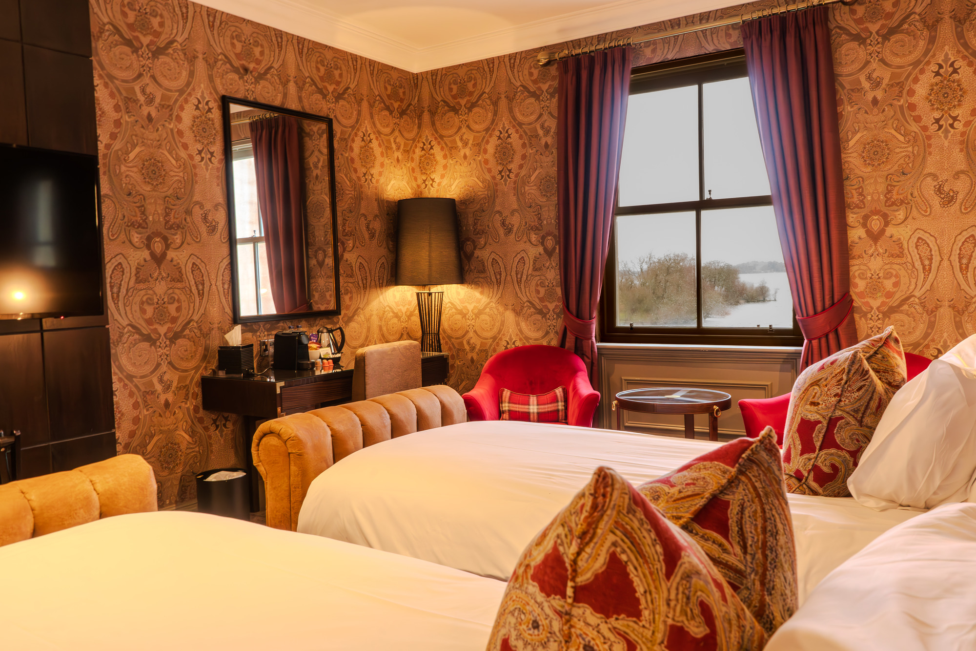 Twin beds in a hotel room with a window overlooking Loch Lomond at Cameron House.