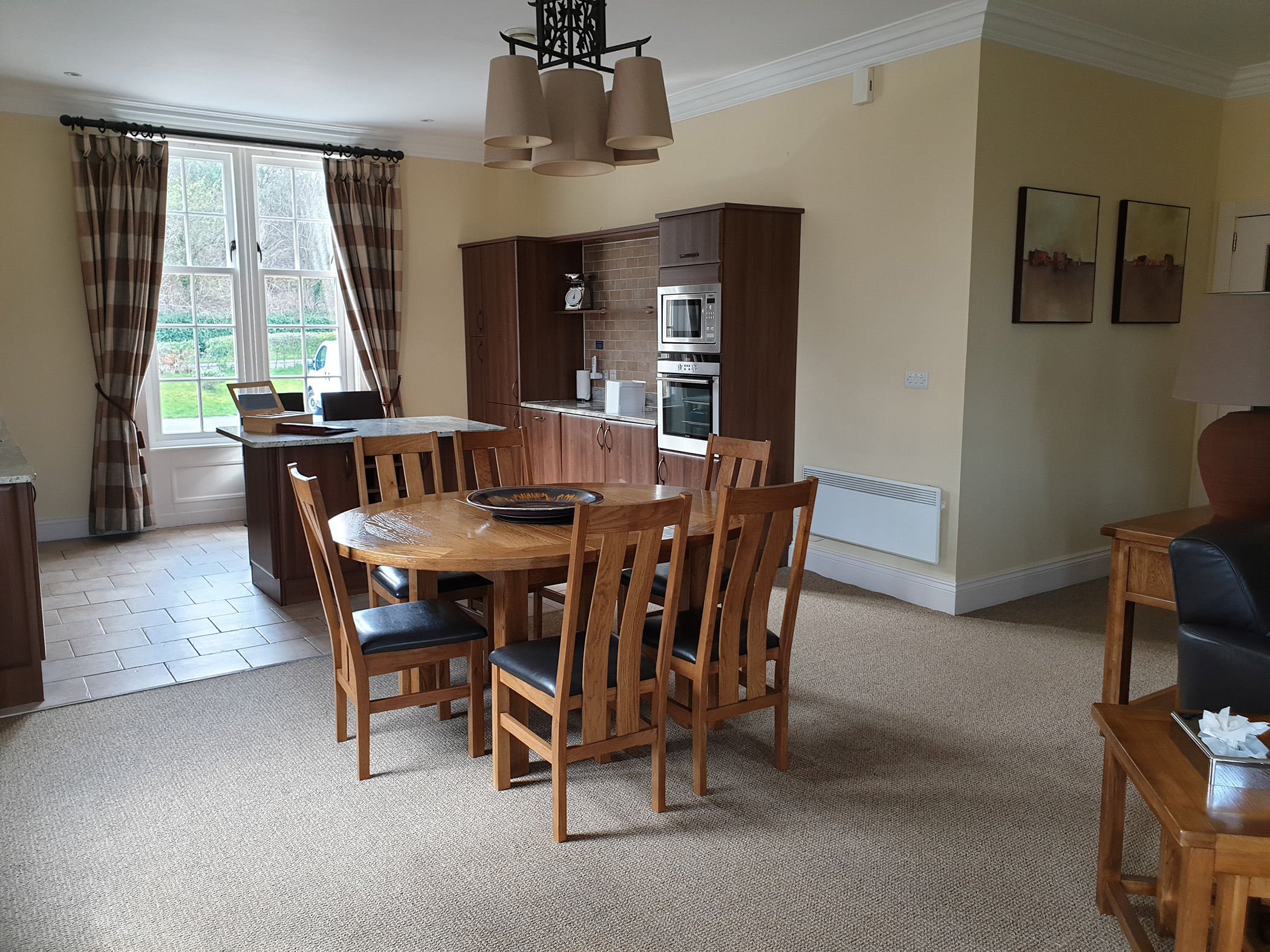 a dining room table with a small kitchenette behind it