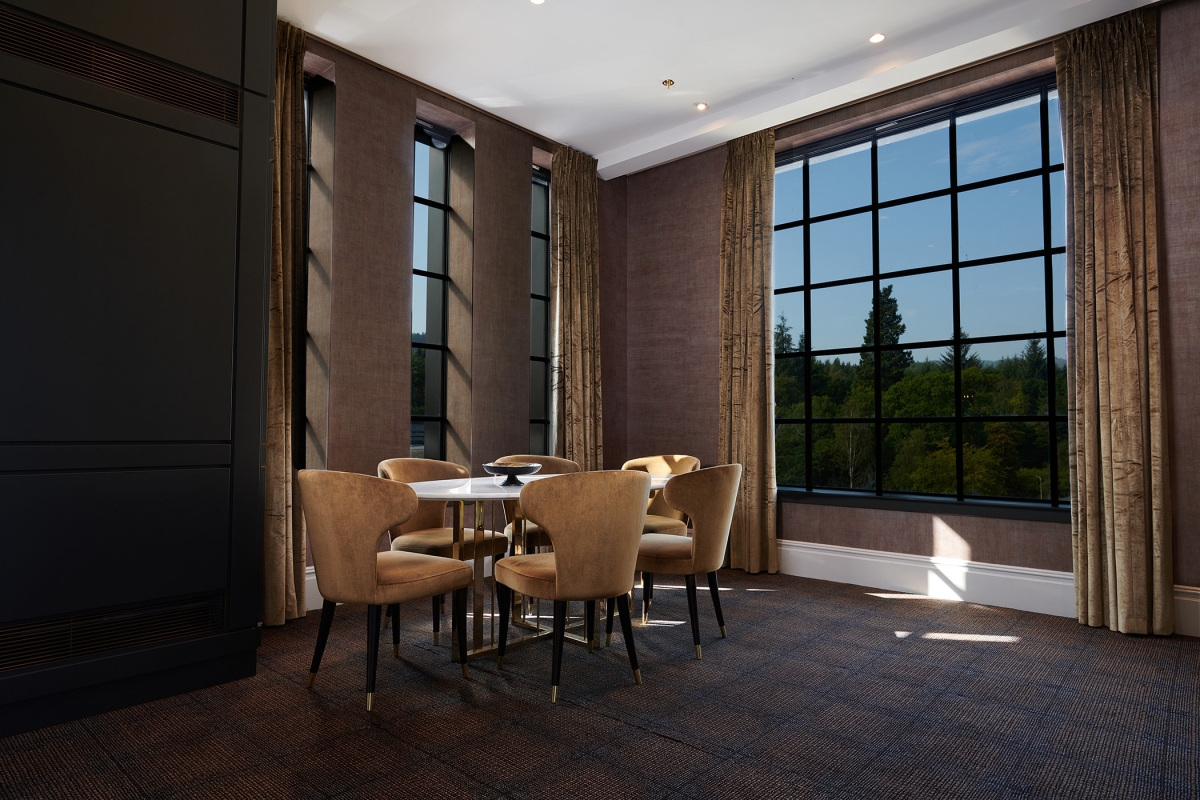 a sitting area next to large windows showing off the trees out side