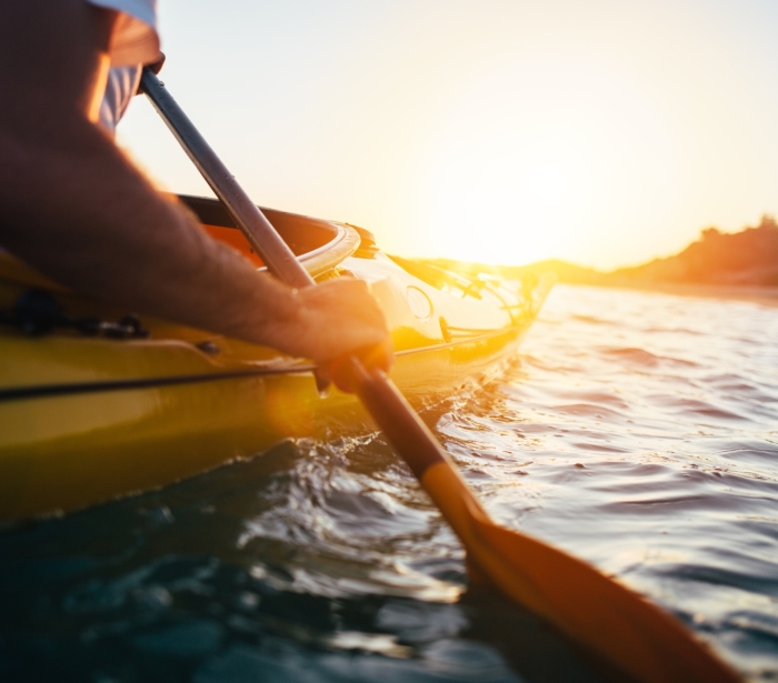 a person sitting in a kayak paddling along the water