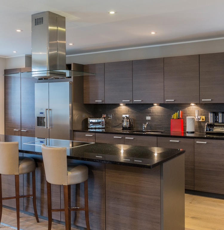 a large open kitchen area with a kitchen island and chairs for seating