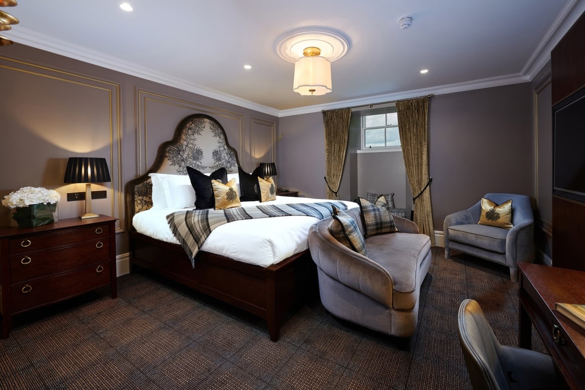 a large bed room with a bed and couches for seating