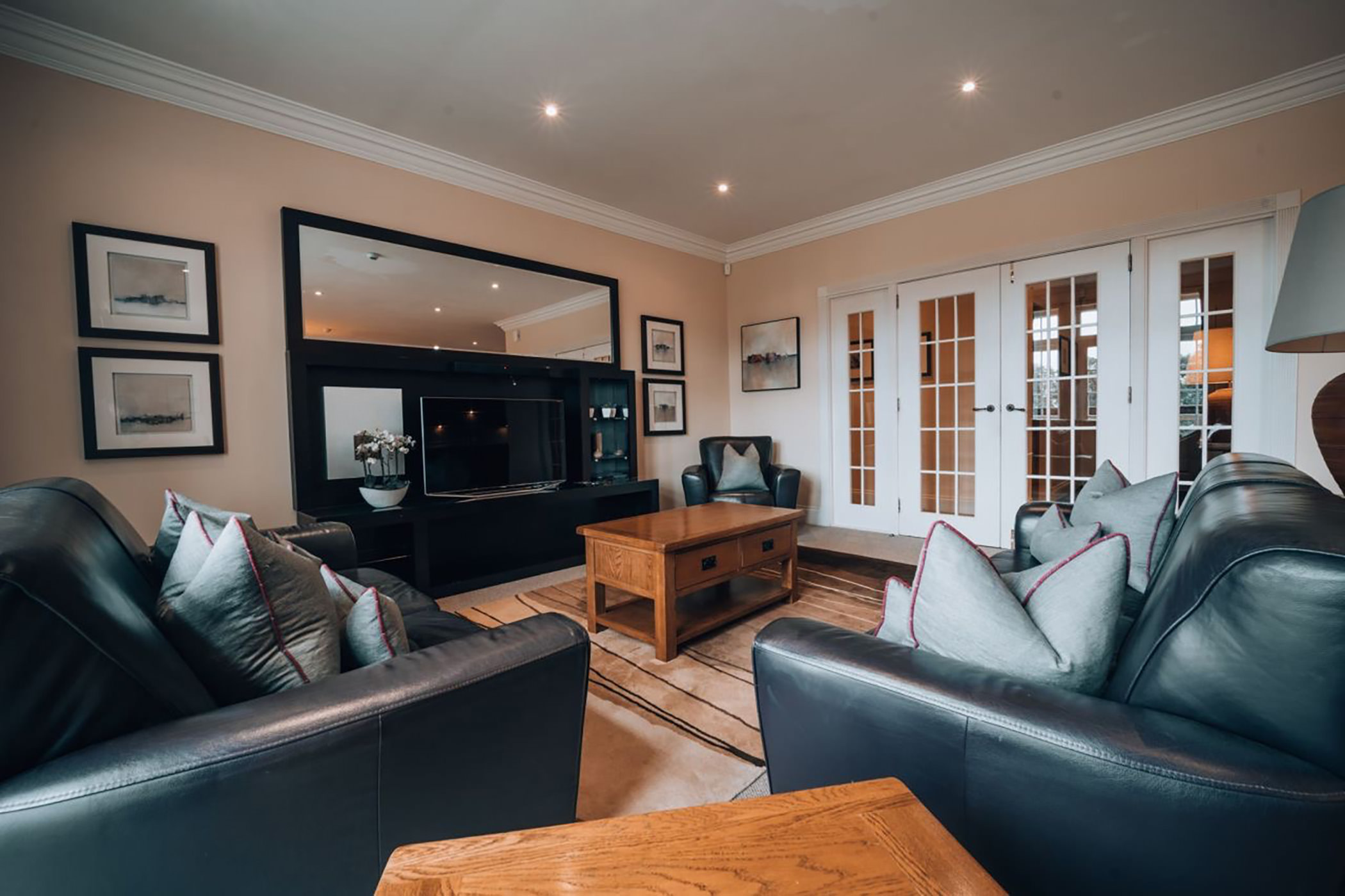 a living room area with black couches and a tv for entertainment