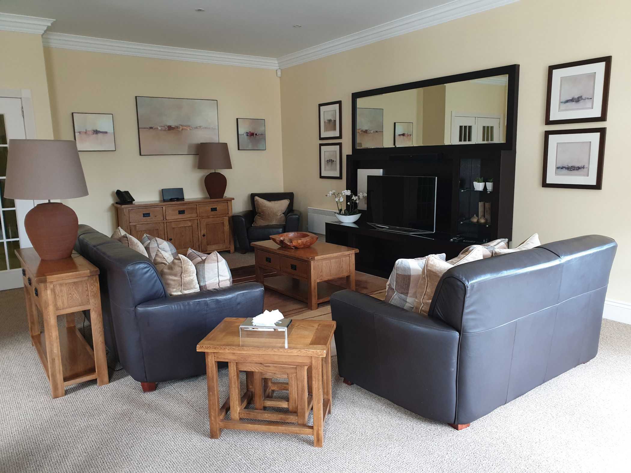 living room area with couches and coffee tables in front of a tv