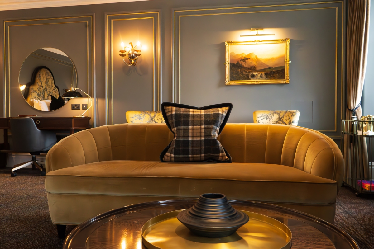 a stunning yellow sofa surrounded by upscale furnishing in the loch view suite at Auld House.