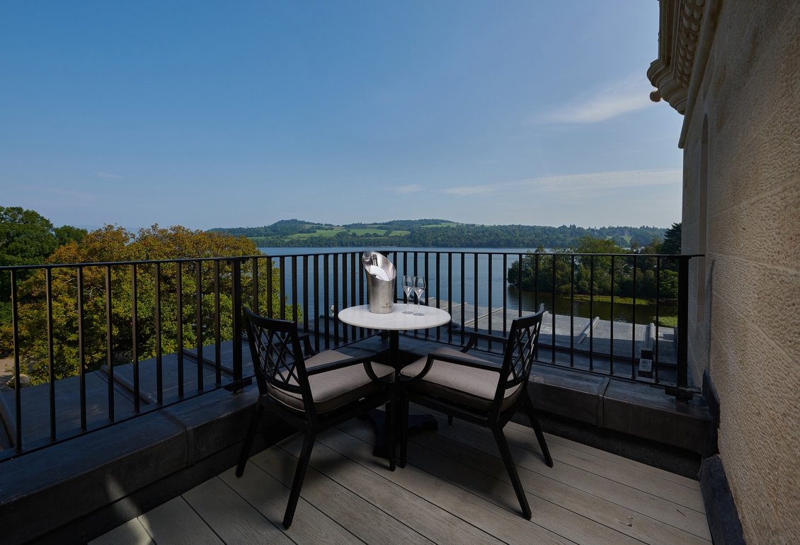 a small sitting area on a patio over looking the water