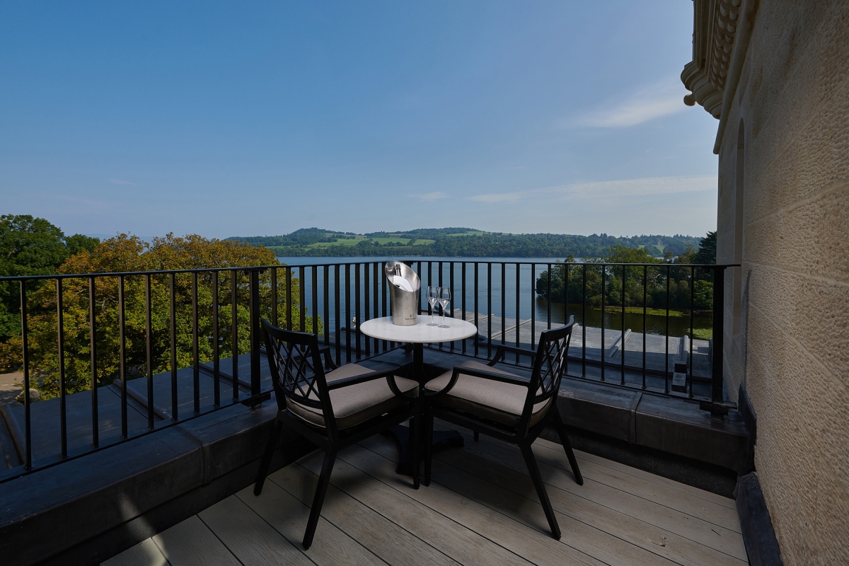 a small sitting area on a patio over looking the water