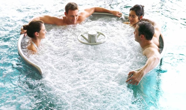 four people sitting in a whirlpool enjoying the relaxing waters