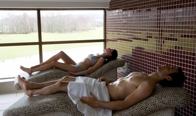 a man and woman laying on spa beds relaxing