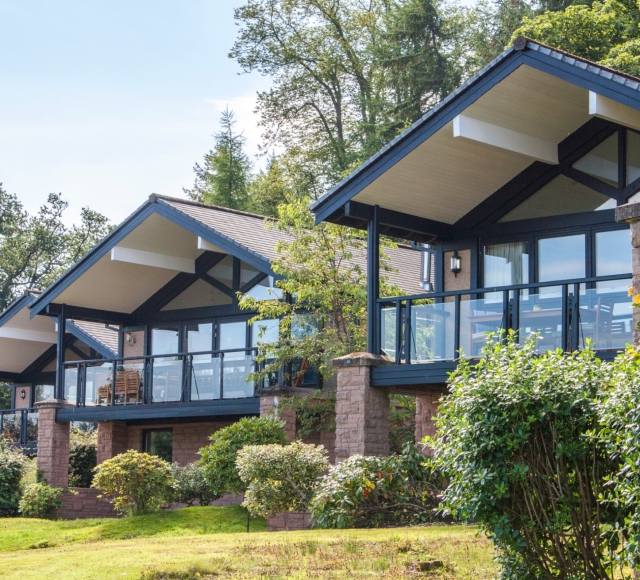 Exterior of the Cameron Lodges with lush green lawns and bushes in the foreground