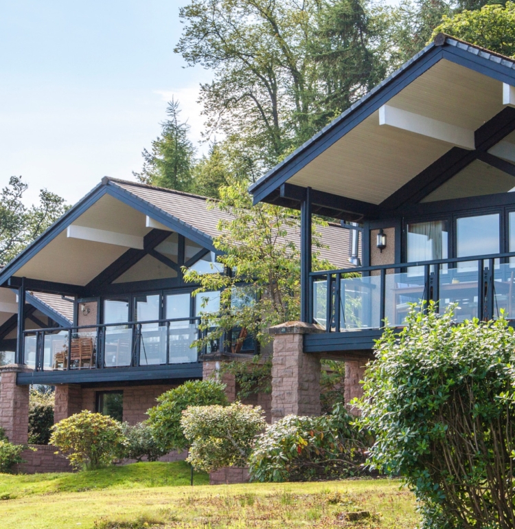 Exterior of the Cameron Lodges with lush green lawns and bushes in the foreground