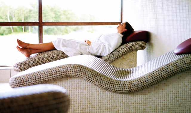 a woman relaxing on a tile chair enjoying the sun shine coming in from the out side