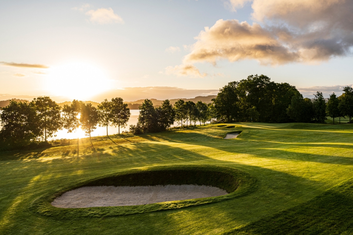 The sun setting behind the trees at the Carrick Golf Course