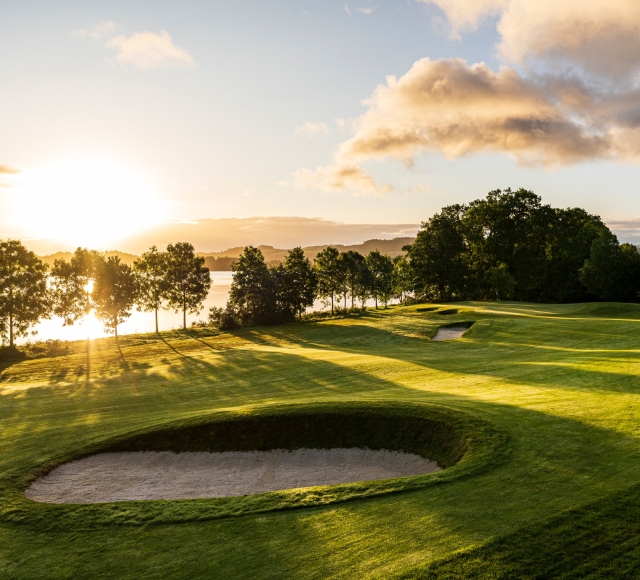 The sun setting behind the trees at the Carrick Golf Course