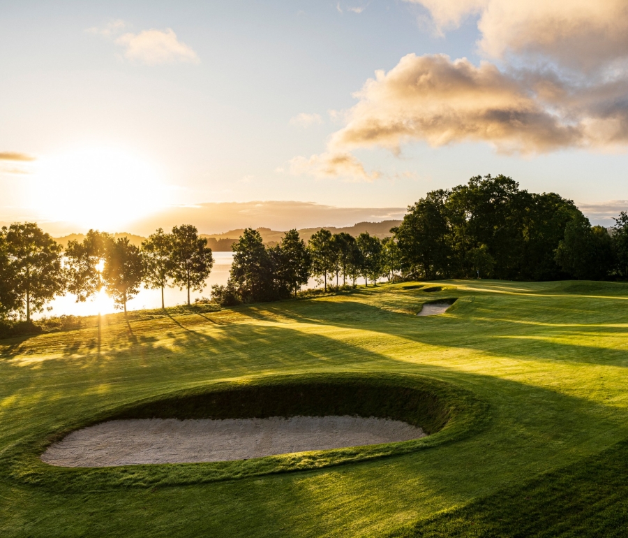 The sun setting behind the trees at the Carrick Golf Course