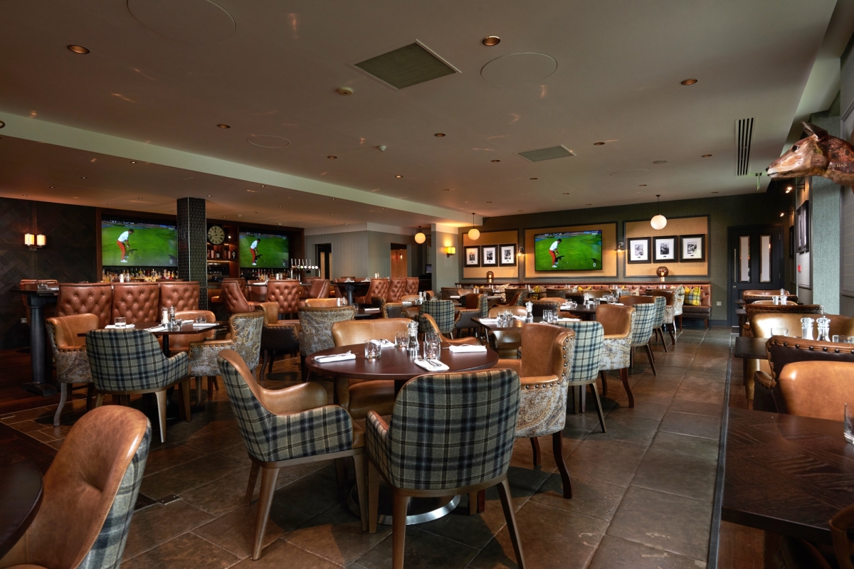 dining room area with chairs and tables and tvs playing golf in the back