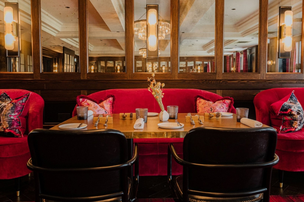 pink chairs in front of a brown table set up for a dining service