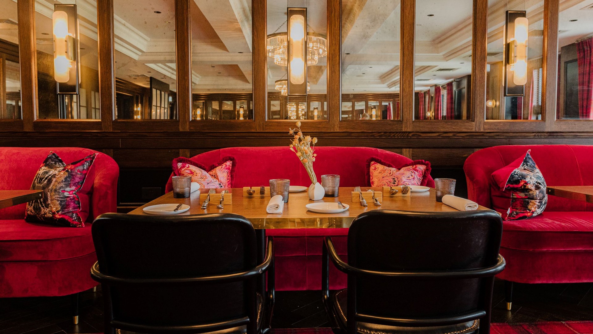 pink chairs in front of a brown table set up for a dining service