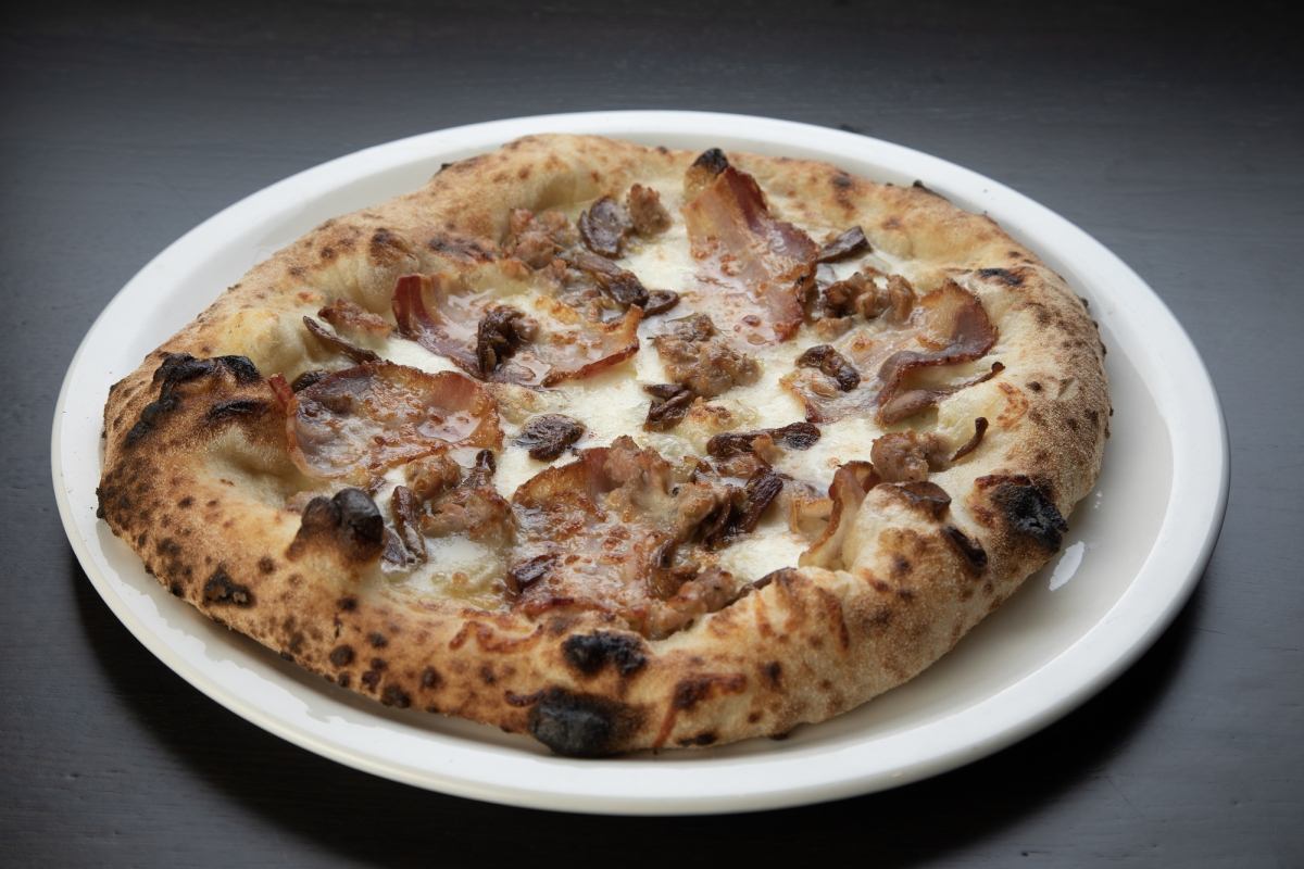 A delicious pizza on a white plate on a table at La Vista restaurant.