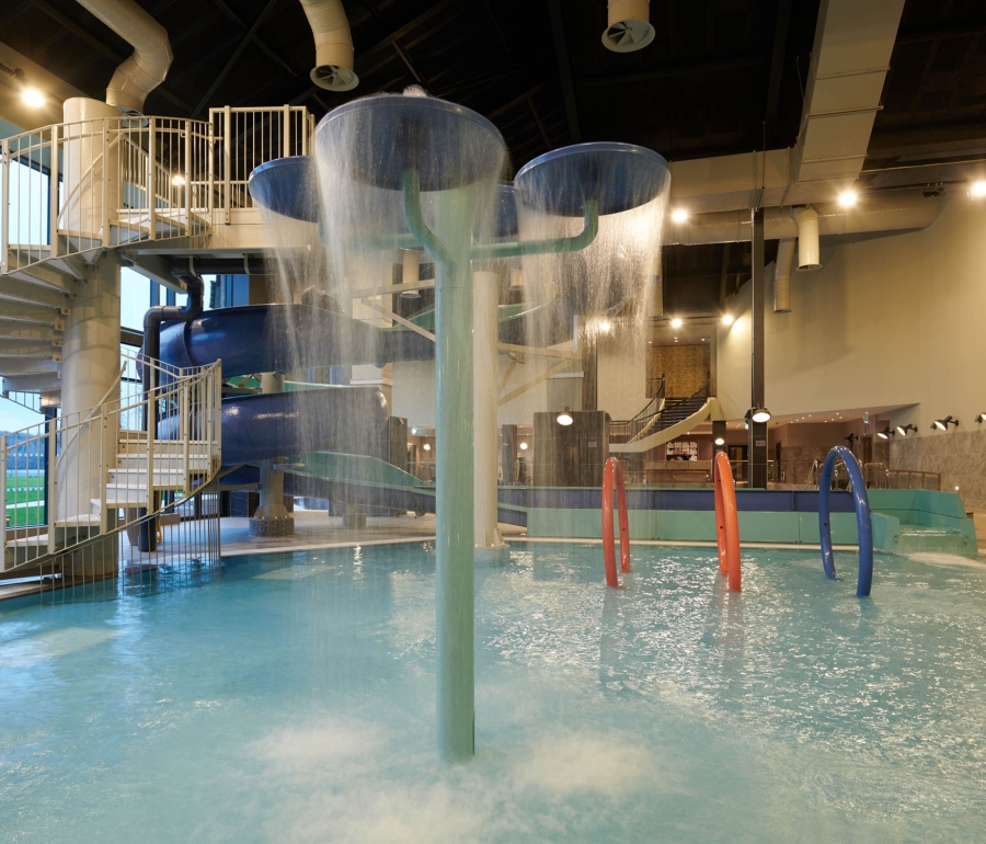 in door pool with stairs leading up to a water slide