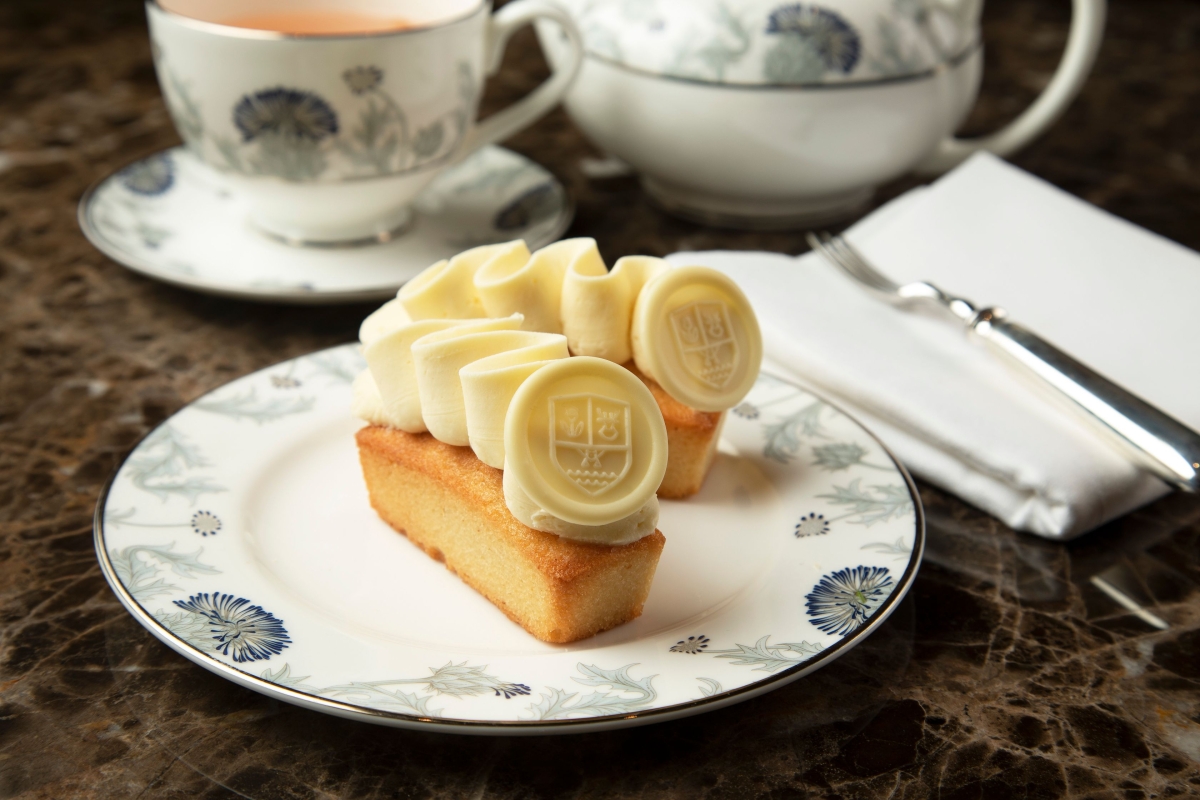 small food sitting on a plate with tea in the background on a table