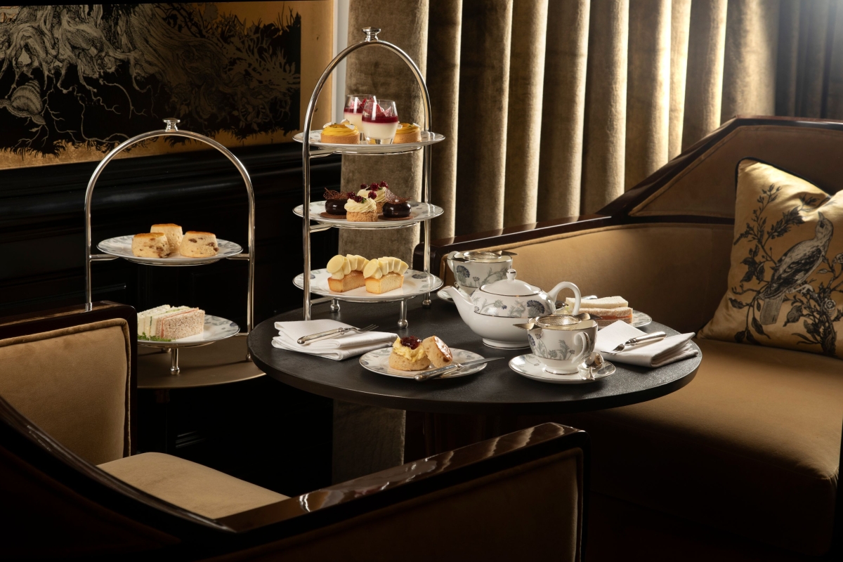 afternoon tea and snacks sitting on a black table and chairs on the side