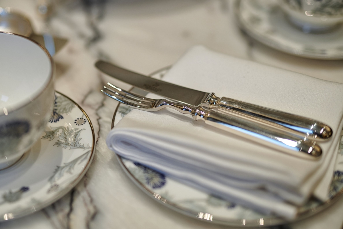 silverware sitting on a white napkin on top of a small plate