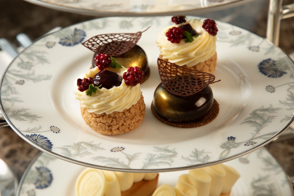some small deserts sitting on a plate ready for afternoon tea