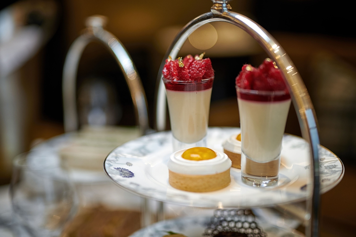 small glasses of raspberries sitting on a plate