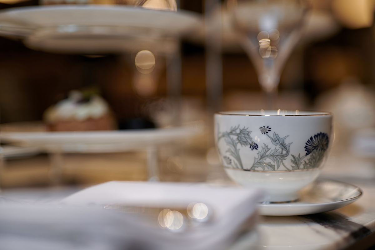 a close up view of a tea cup with flowers painted on the side
