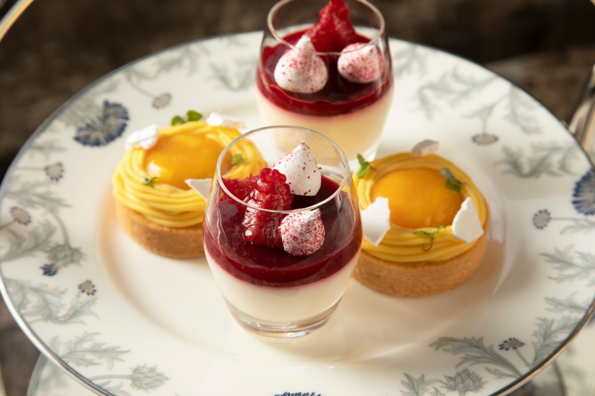 glasses of fruit sitting next to tarts on a plate