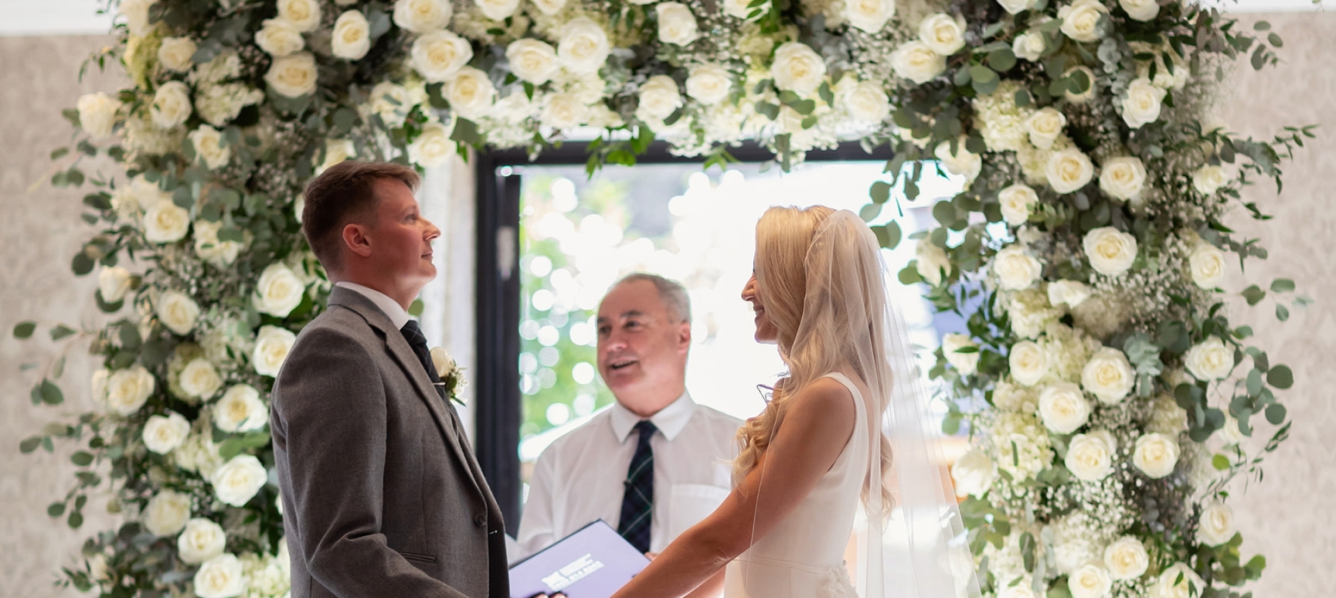 a bride and groom standing in front of a officiant ready to be married