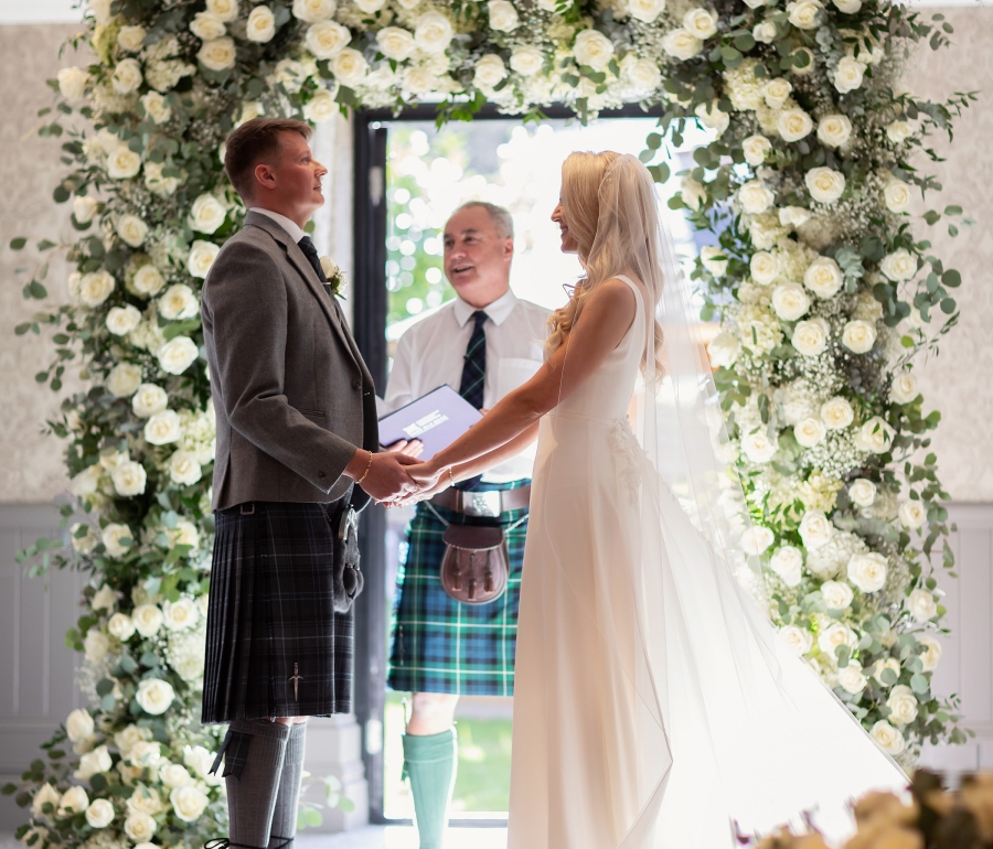 a bride and groom standing in front of a officiant ready to be married