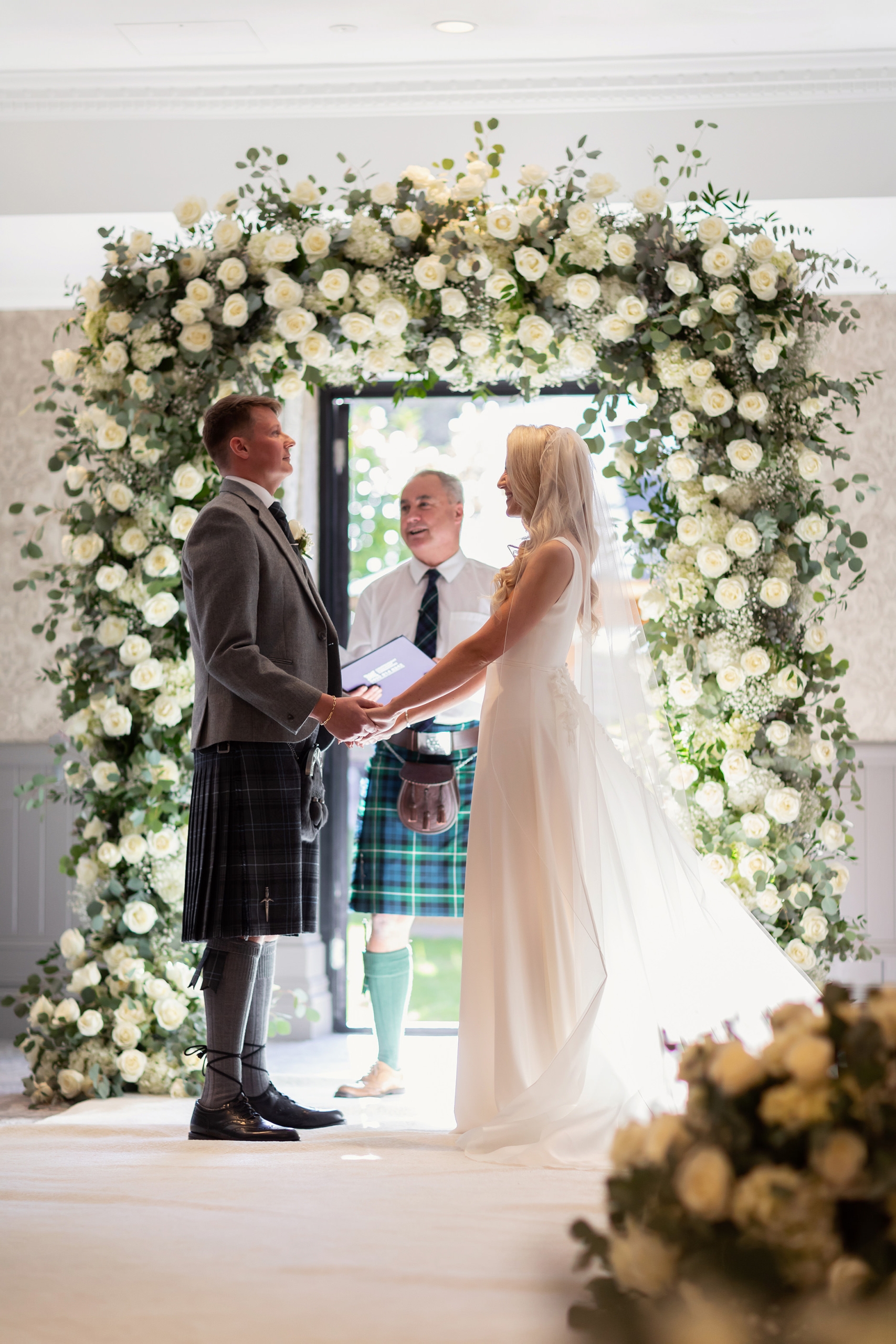 a bride and groom standing in front of a officiant ready to be married