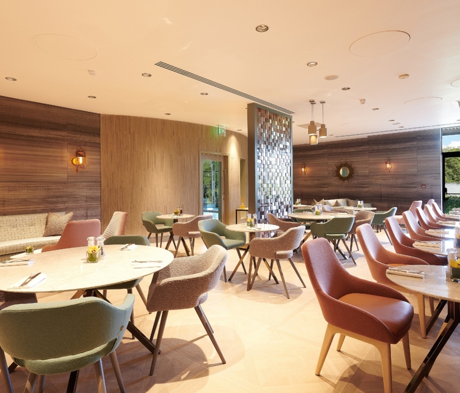 a beautiful dining room with round tables and colourful chairs