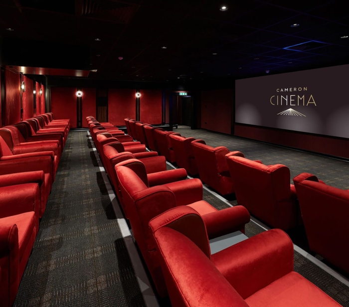 Cameron cinema located in Cameron house with rows of seating available