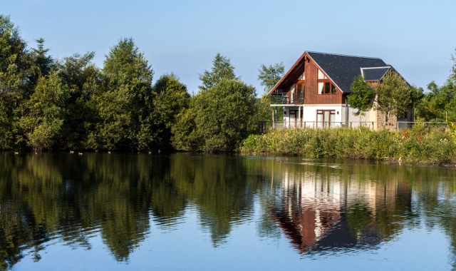 a lodge sitting on the edge of a lake over looking the water